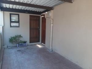 an entrance to a house with a door and a plant at The Pool Cottage in Fish hoek