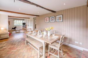 un comedor con una mesa larga y sillas en The Farmhouse Boundary Farm Framlingham Air Manage Suffolk, en Woodbridge