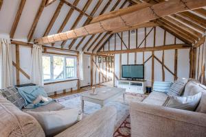 a living room with two couches and a tv at The Hayloft Boundary Farm Air Manage Suffolk in Woodbridge
