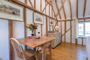 a dining room with a wooden table and chairs at The Hayloft Boundary Farm Air Manage Suffolk in Woodbridge