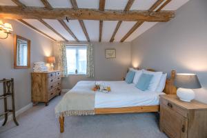 a bedroom with a large bed with white sheets and blue pillows at The Hayloft Boundary Farm Air Manage Suffolk in Woodbridge