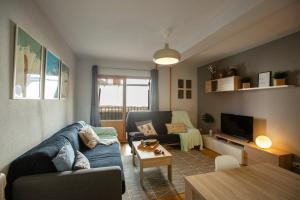 uma sala de estar com um sofá azul e uma mesa em PirineosK · GORGOL · Confort y funcionalidad · con balcón em Formigal