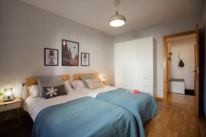 um quarto com uma cama grande e lençóis azuis em PirineosK · GORGOL · Confort y funcionalidad · con balcón em Formigal