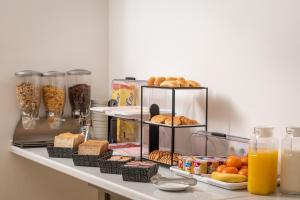 a shelf filled with different types of bread and orange juice at Hostal Baler in Barcelona
