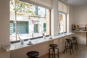 un bar con sgabelli di fronte a una finestra di Hostal Baler a Barcellona