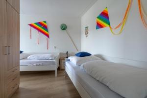 - 2 lits dans une chambre avec des cerfs-volants accrochés au mur dans l'établissement Residence Juliana appartement 53 -Julianadorp aan zee, à Julianadorp