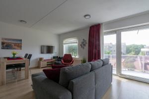 - un salon avec un canapé, une table et un piano dans l'établissement Residence Juliana appartement 53 -Julianadorp aan zee, à Julianadorp