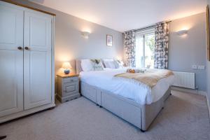a bedroom with a large bed and a window at The Cartlodge Boundary Farm Air Manage Suffolk in Woodbridge