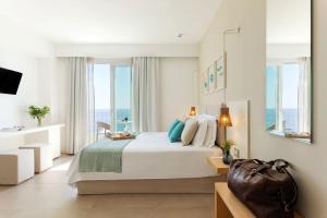 a bedroom with a bed with a view of the ocean at Albatros Beach Hotel in Letojanni