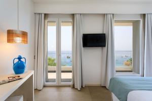 a bedroom with a bed and a view of the ocean at Albatros Beach Hotel in Letojanni