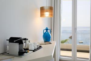 a table with a blue vase sitting on top of a counter at Albatros Beach Hotel in Letojanni