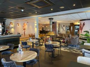 a restaurant with tables and chairs in a room at Hotel Restaurant Talens Coevorden in Coevorden