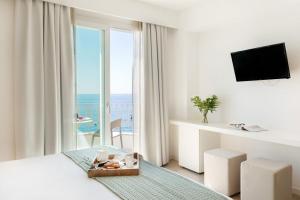 a bedroom with a bed with a view of the ocean at Albatros Beach Hotel in Letojanni