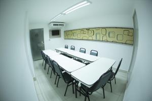 ein Zimmer mit Tischen, Stühlen und einem Spiegel in der Unterkunft Hotel Central Caruaru in Caruaru