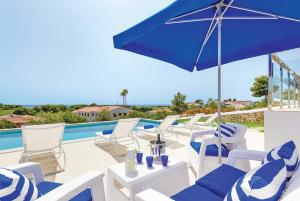 a group of chairs and an umbrella next to a swimming pool at Paradise in Son Bou