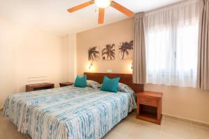 a bedroom with a bed with blue pillows at Apartamentos Vista Sur in Playa de las Americas