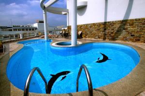 a swimming pool with dolphins in the water at Asia Paradise Hotel in Nha Trang