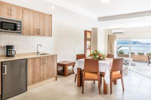 a kitchen with a table and chairs and a refrigerator at Apartamentos Vista Sur in Playa de las Americas