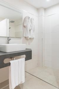 a white bathroom with a sink and a mirror at Apartamentos Vista Sur in Playa de las Americas