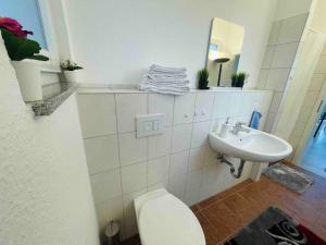 a bathroom with a toilet and a sink at Schönes Bungalow, Check-In Kontaktlos, Zentral in Duisburg