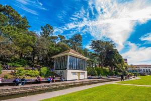 a group of people sitting on benches in a park at Spacious 4 Bed Rooms, Parking, Garden and Near Parks, Beaches and University in Bournemouth