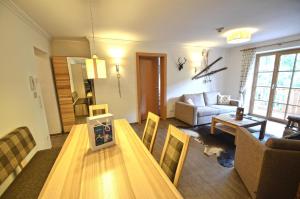 a living room with a table and a couch at Appartementhaus Kristall at SchattbergXpress by All in One Apartments in Saalbach Hinterglemm