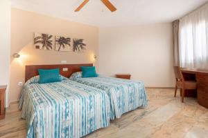 a bedroom with two beds and a piano at Apartamentos Vista Sur in Playa de las Americas