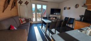 a living room with a couch and a table and a kitchen at Résidence Campredon - 6 à 8 pers - Terrasse 25m2 plein sud - Jardin - Internet - Parking - Navette pied du logement - Linge Inclus - Ménage en option in Font-Romeu