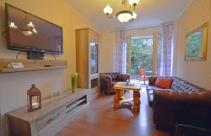 ein Wohnzimmer mit Ledermöbeln und einem Flachbild-TV in der Unterkunft Apartamenty Bryza-Komandorska 3E- Family Home - Parking in Świnoujście