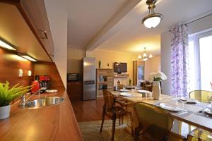 una cucina e un soggiorno con tavolo e sedie di Apartamenty Bryza-Komandorska 3E- Family Home - Parking a Świnoujście