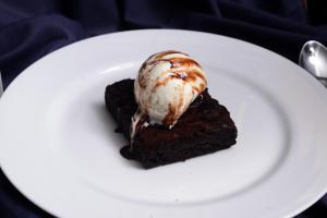 a piece of chocolate cake with ice cream on a white plate at The Hawaii Comforts Panjim in Panaji