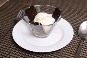 a cup of ice cream on a plate with a fork at The Hawaii Comforts Panjim in Panaji