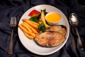 a plate of food with chicken and vegetables and a sauce at The Hawaii Comforts Panjim in Panaji