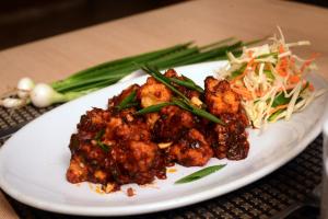 a plate of food with meat and vegetables on a table at The Hawaii Comforts Panjim in Panaji