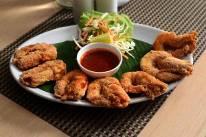a plate of food with fried calamari and dipping sauce at The Hawaii Comforts Panjim in Panaji