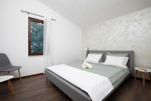 sypialnia z łóżkiem z białymi ścianami i oknem w obiekcie Sandy Bay Apartments - free mountainbike rental - w mieście Pješčana Uvala +37 zdjęć