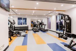 a gym with treadmills and ellipticals at Resivation Hotel in Dubai
