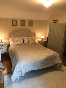 a bedroom with a large bed with two night stands at Old Mutlow Cottage in Longhope