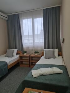 a hotel room with two beds and a window at Garni hotel Alma in Pirot