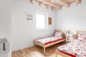 a bedroom with two beds and a window at Babiogórska Perełka w skandynawskim stylu z sauną i kominkiem in Jordanów