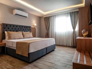 a bedroom with a large bed and a window at Hotel Bleu Nuit in Bodrum City