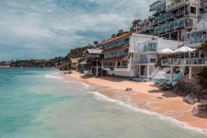 Legends Beachfront Resort في أُلُواتو: اطلالة على شاطئ به مباني و المحيط