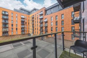 a balcony with a chair and a building at 2 BED AT SLOUGH STATION & PARKING - LONDON IN 20 MINS in Slough