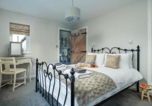 um quarto com uma cama e uma secretária com uma televisão em Finest Retreats - Esmor Cottage em Caerwys