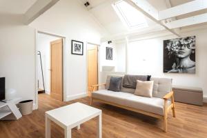 a living room with a couch and a table at Curb Properties - Cool Trendy Montpellier Apartment in Cheltenham