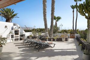 d'une terrasse avec des bancs, des arbres et des palmiers. dans l'établissement Puerto Chico T, à Playa Blanca