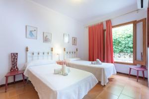 two beds in a room with a window at YupiHome Villa Ànecs in Alcudia