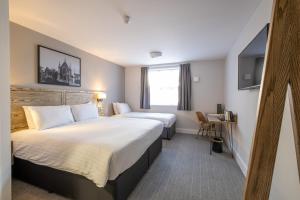 um quarto de hotel com duas camas e uma janela em Two Rivers Lodge by Marston’s Inns em Chepstow