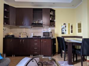 a kitchen with brown cabinets and a table with chairs at Apartman Mina in Kopaonik