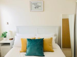 a bedroom with a white bed with yellow and blue pillows at Centre of Birmingham, 2 Bedroom - Perfect for Families, Group, or Business in Birmingham
